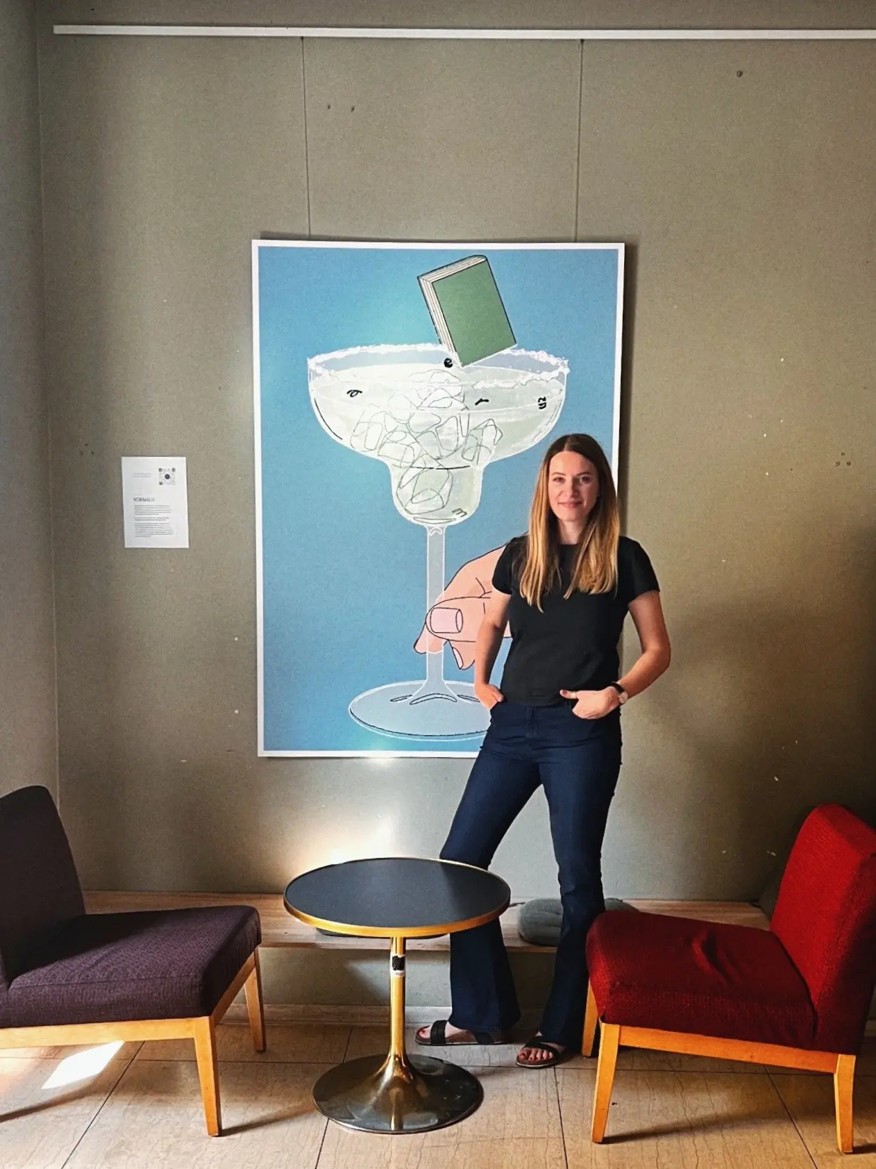 Agne Pet standing next to her artwork during exhibition